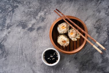 Çin buğulama köfteleri ya da bambu tenceresinde koyu soyut arka planda Dim Sum.