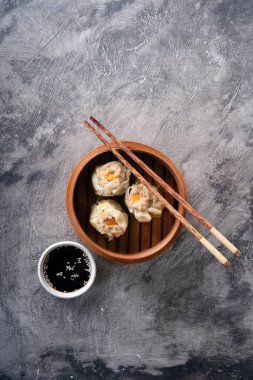 Çin buğulama köfteleri ya da bambu tenceresinde koyu soyut arka planda Dim Sum.