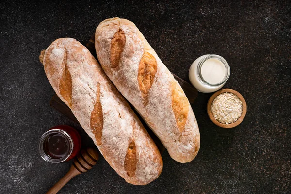 stock image Fresh homemade artisan loaf of baguette breads on rustic background with copy space. sourdough mini baguette breads.