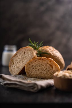 Kırsal arka planda susam tohumlu ev yapımı kahverengi çörekler. Sağlıklı zanaatkar ekmeği.