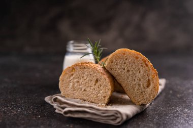 Kırsal arka planda susam tohumlu ev yapımı kahverengi çörekler. Sağlıklı zanaatkar ekmeği.