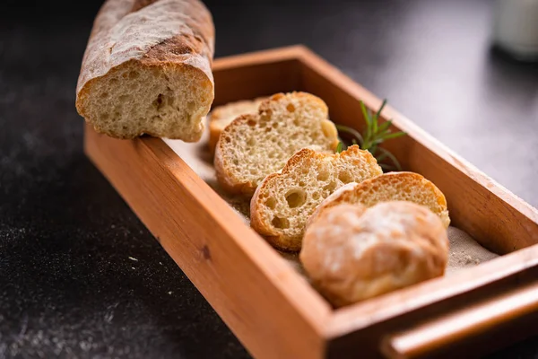 木製のコースターや素朴な背景にスライスしたバゲットパン 職人の生地パン — ストック写真