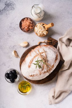 Taze organik ciabatta ekmeği, otlar, zeytinyağı ve beyaz kırsal arka planda zeytinyağı. mayalı ekmek