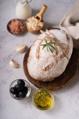 Taze organik ciabatta ekmeği, otlar, zeytinyağı ve beyaz kırsal arka planda zeytinyağı. mayalı ekmek