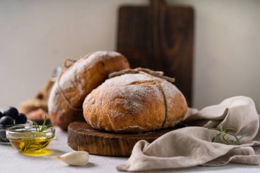 Taze organik ciabatta ekmeği, otlar, zeytinyağı ve beyaz kırsal arka planda zeytinyağı. mayalı ekmek