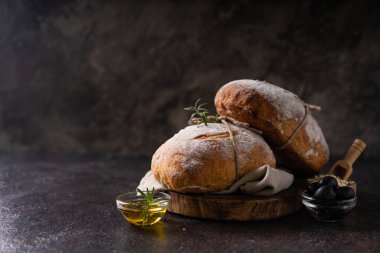 Koyu kırsal arka planda taze organik ciabatta ekmeği. mayalı ekmek