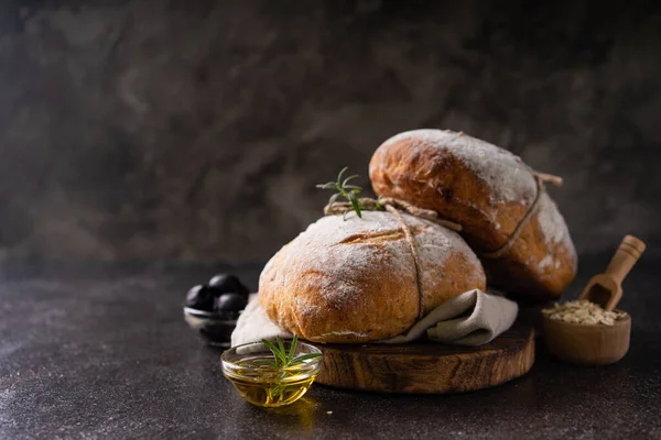 Čerstvě Upečený Kysaný Ciabatový Chléb Olivami Rozmarýnem Černém Venkovském Stole — Stock fotografie