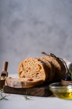 Beyaz soyut bir masa üzerinde zeytinli ve biberiyeli ev yapımı ekşi ciabatta dilimi. Esnaf ekmeği