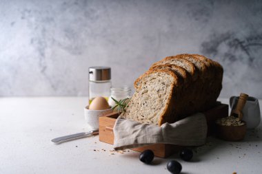 Beyaz rustik arka planda taze dilimlenmiş ev yapımı kepekli kepekli buğday ekmeği zeytinyağı. Esnaf Ekşi Hamur