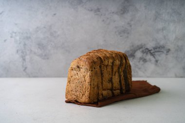 Beyaz rustik arka planda taze dilimlenmiş ev yapımı kepekli kepekli buğday ekmeği zeytinyağı. Esnaf Ekşi Hamur