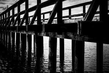 İsveç 'in Rttvik şehrinde tahtadan (Lngbryggan) yapılmış siyah beyaz köprü. Fotoğraf Temmuz 2024 'te çekildi..