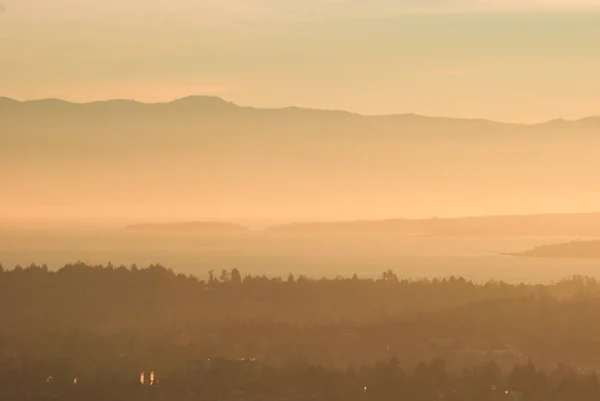 stock image Hazy or smoky sunset over the south of Vancouver Island with the Olympic Peninsula in the distance.