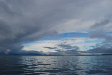 Fırtına bulutlarının yansımaları dalgalı ama sakin Juan De Fuca Boğazı Victoria yakınlarında, BC