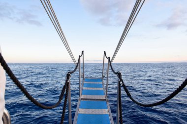 View from a boat with ladder suspended over ocean water