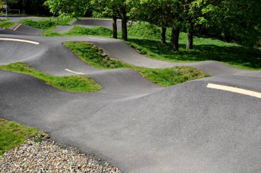 Spor ve yarış etkinlikleri için pürüzsüz bir yüzey üzerinde zıplamalı ve köşeli bisiklet pisti veya dağ bisikletleri