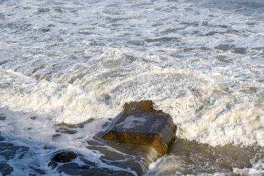 Concrete sewer pipes in the ocean leading to marine outfall into the sea potentially polluting the environment clipart