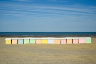 Kumsaldaki kulübeler, kumdaki pastel gölgelerle renklidir.