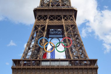 Paris, Fransa - Ağustos 2024 Paris bu yıl Olimpiyat Oyunlarına ev sahipliği yaptı ve Olimpiyat yüzük sembolü Eyfel Kulesi 'ndeki Fransız bayrağıyla asılı duruyor