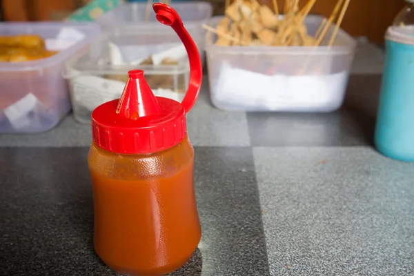 a bottle of hot sauce on the canteen table