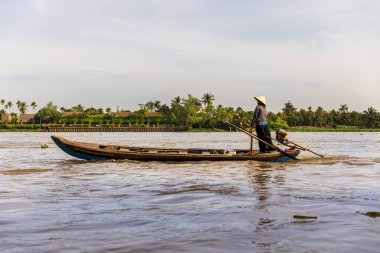 Vietnamlı bir kadın Mekong Nehri 'nden tekneyle geçiyor.