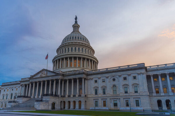 The United States Capitol building at blue hour with American flag