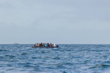 Migrants on a boat crossing the channel between France and UK heading towards the port of Dover. clipart