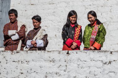 Geleneksel giysiler içinde Butanese halkı geleneksel Trongsa Dzong, Butan Tsechu 'sunu izliyor.