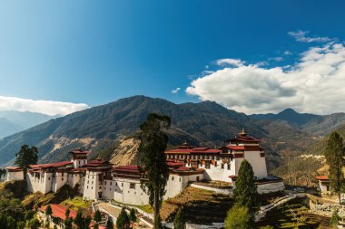 Mavi gökyüzü güneşli bir günde Trongsa Dzong manzarası