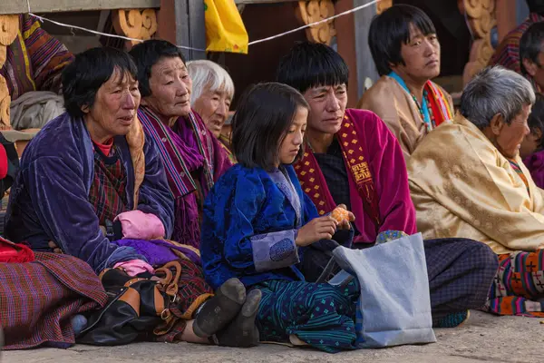 Geleneksel giysiler içinde Butanese halkı geleneksel Trongsa Dzong, Butan Tsechu 'sunu izliyor.