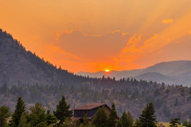 Yellowstone Milli Parkı üzerinde günbatımı Tipik ahır ve dağların silueti.