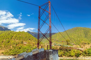 Hanging footbridge over the Mo Chuu river in Bhutan clipart