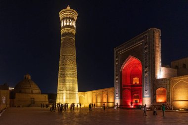 Bu resimde, tarihi Poi Kalon İslam kompleksinin geceleri aydınlanan önemli unsurları olan ikonik Kalyan Minaresi ve Kalyan Camii yer alıyor..