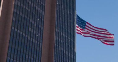 Arka planda mavi gökyüzü dalgalanan Amerika bayrağı