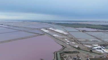 Güney Fransa, Camargue 'deki Aigues-Mortes tuzlu bataklıklarının hava manzarası. Aigues Mortes 'de tuz çiftliği ve güzel pembe bir göl. Tuz üretimi