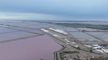 Güney Fransa, Camargue 'deki Aigues-Mortes tuzlu bataklıklarının hava manzarası. Aigues Mortes 'de tuz çiftliği ve güzel pembe bir göl. Tuz üretimi
