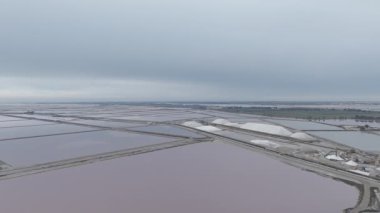 Güney Fransa, Camargue 'deki Aigues-Mortes tuzlu bataklıklarının hava manzarası. Aigues Mortes 'de tuz çiftliği ve güzel pembe bir göl. Tuz üretimi