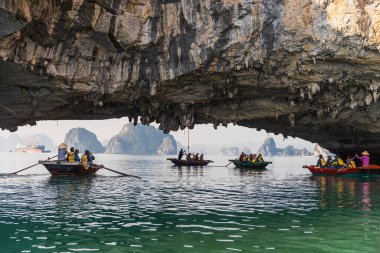 Bir grup turist, yüksek kireçtaşı mağarasının altındaki küçük teknelerde kürek çekiyor. Kayıklar yüzyıllar süren su erozyonunun oyduğu doğal bir tünelden geçerken başımızın üstünde dramatik kaya oluşumları beliriyor..