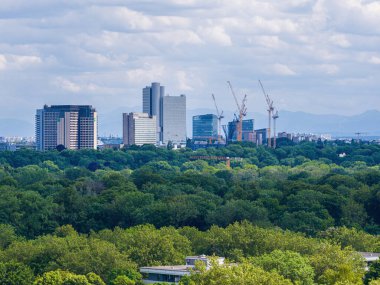 Aerial footage of the Munich Denning skyline combined with a construction site of a modern office complex at Richard-Strauss-Strasse, showing urban development and contemporary architecture.