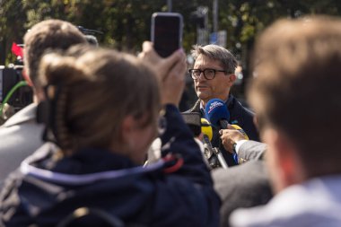 Press spokesman of the city of Munich , giving a media statement to journalists regarding the temporary closure of the Oktoberfest after a bomb threat.