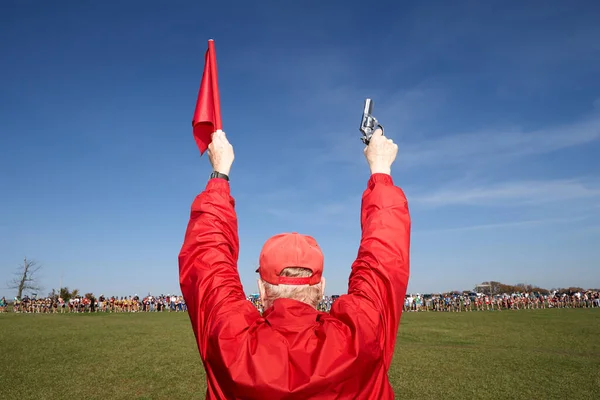 Mężczyzna Ubrany Czerwono Stojący Plecami Kamery Twarzą Pola Zawodników Trzymających — Zdjęcie stockowe