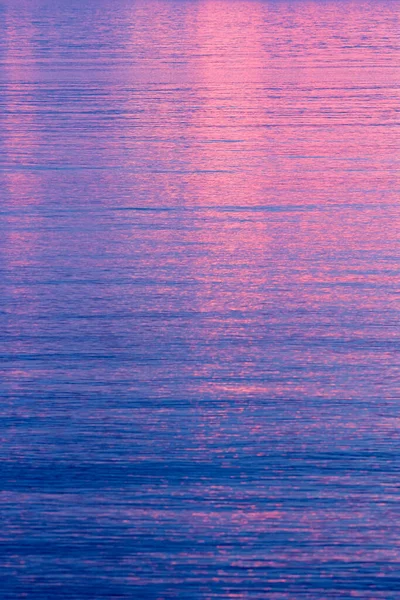 フルフレームの天気の背景に穏やかな青い水に反映鮮やかなピンクの夕日や日の出 — ストック写真