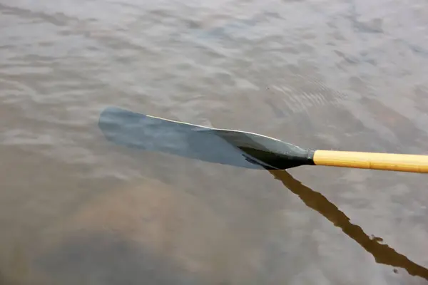stock image Aluminum oar blade dipping underwater when rowing on a freshwater lake or river in a close up view