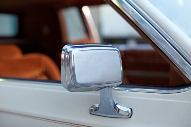 Arka planda yan penceresi olan ve boşluğu kopyalayan klasik bir klasik klasik klasik araba üzerinde krom ve beyaz bir kanat aynası.