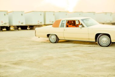 Eski tarz eski model bir araba eski bir endüstriyel depoda patinaj çekiyor..