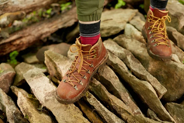 石の上を歩く茶色のハイキングブーツの人の足 — ストック写真