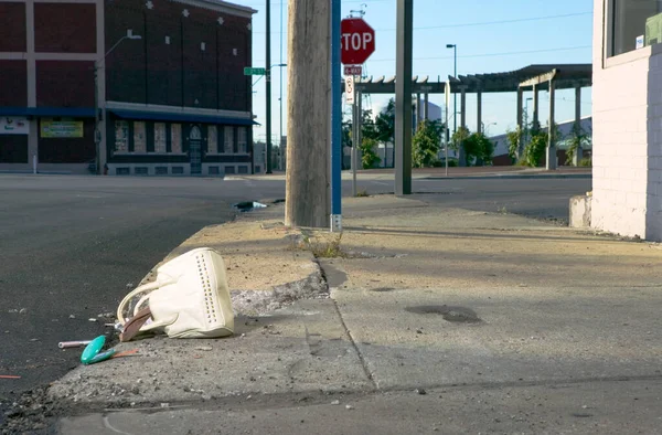 在一个废弃的城市交叉口的人行道上 一个装满财物的手提包被打坏了 — 图库照片