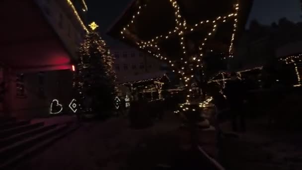 旧市街広場の美しい冬の夜でした 市場は屋台を閲覧し お祝いの雰囲気を楽しんでいる人でいっぱいです クリスマスツリー ライト 装飾があちこちにあります アメリカ合衆国大統領 — ストック動画