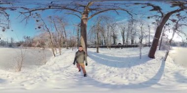 Bu 360 derecelik videoda karlı bir ormanda yürüyüşe çıkın. Video, karla kaplı ağaçlar ve donmuş bir göl ile kış manzarasının güzelliğini yakalıyor. Adam yeşil bir ceket giyiyor ve...
