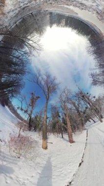Karla kaplı bir orman yolunun büyüleyici güzelliğine kendinizi daldırın, 360 derecelik büyüleyici bir kamerayla hayata döndürün. Video sizi sakin bir kış harikalar diyarına götürüyor.