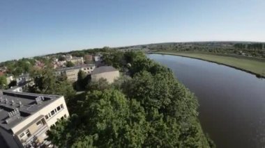 Huzurlu bir nehir ve yemyeşil bir parkın nefes kesici hava turuyla kendinizi doğanın büyüleyici güzelliğine daldırın. Dönen nehirlerden yavaşça akan ağaçların canlı dokusuna ve